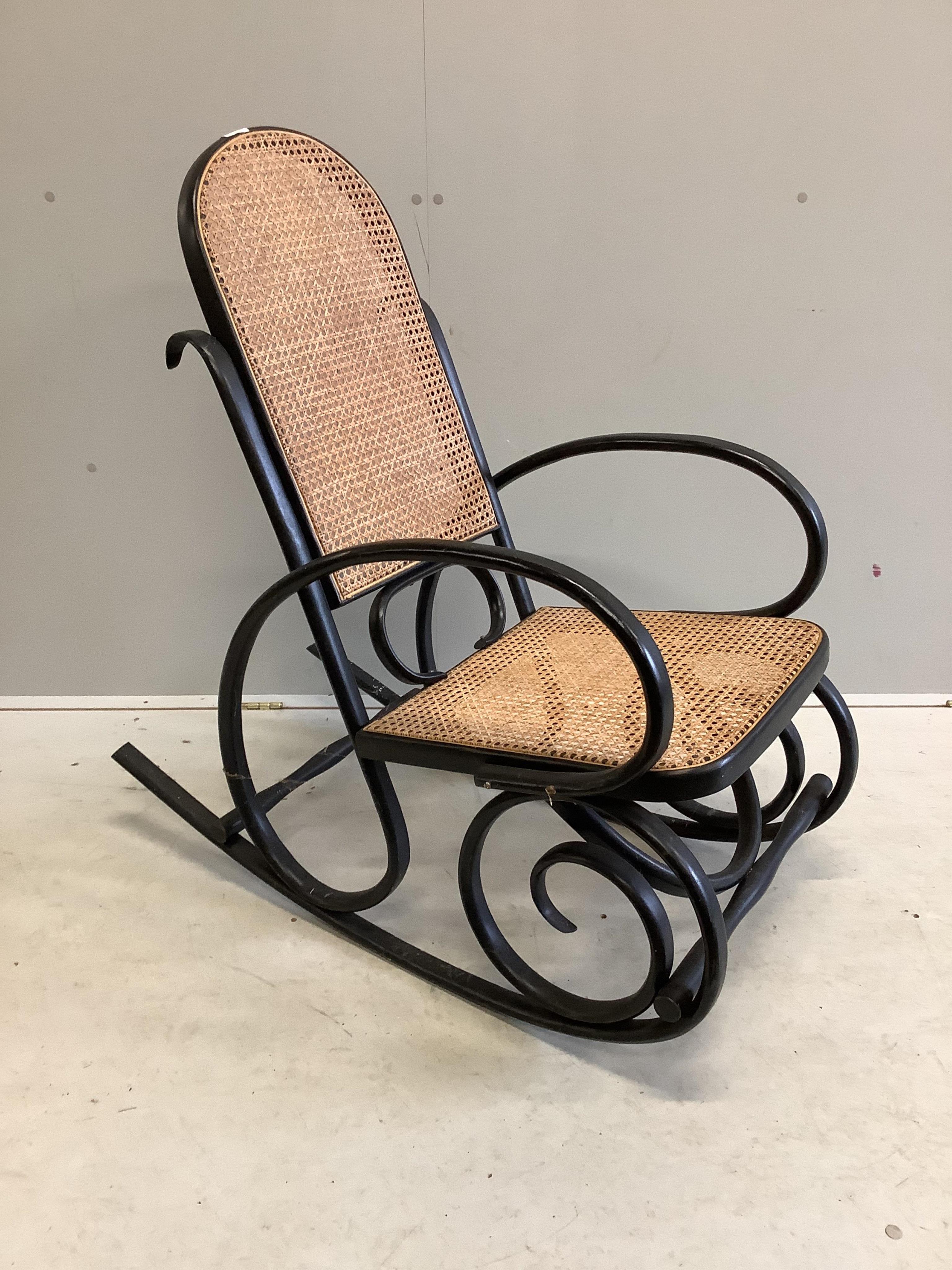 An early 20th century ebonised caned bentwood rocking chair, possibly Thonet, width 53cm, depth 100cm, height 100cm. Condition - fair to good